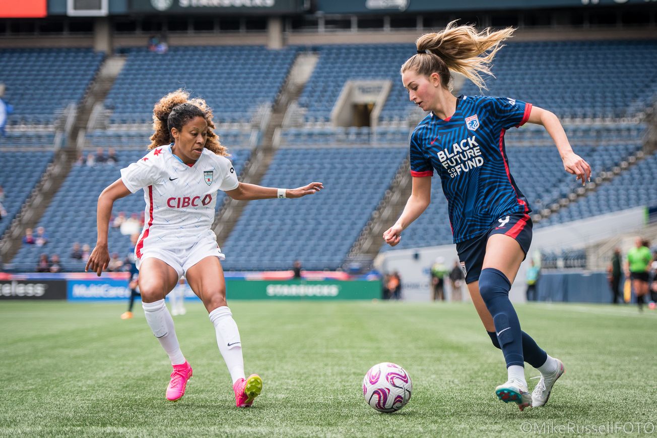 Photo of OL Reign’s Jordyn Huitema challenging Chicago Red Stars defender Casey Short for a ball inn April 2023.