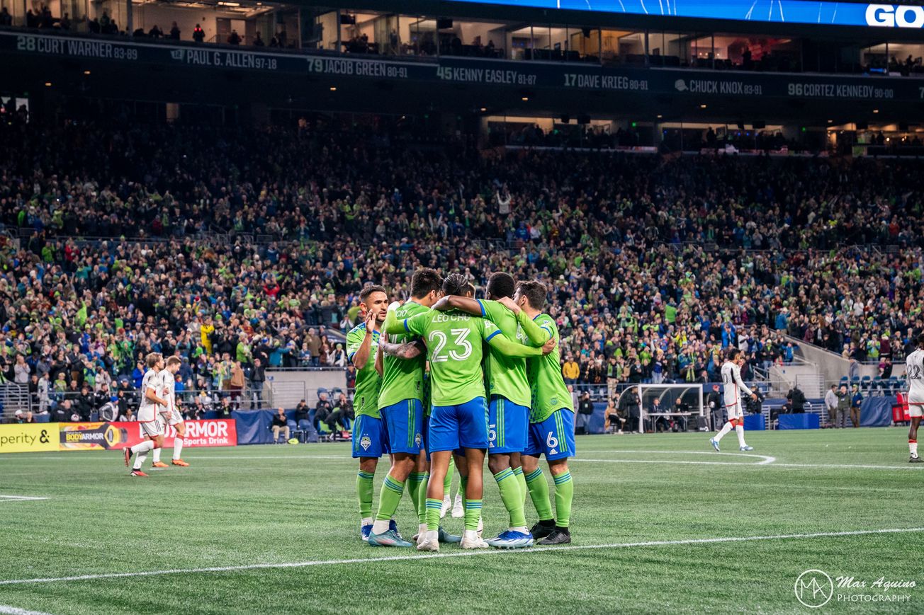 Members of the Seattle Sounders huddle in celebration following a goal against FC Dallas at Lumen Field.