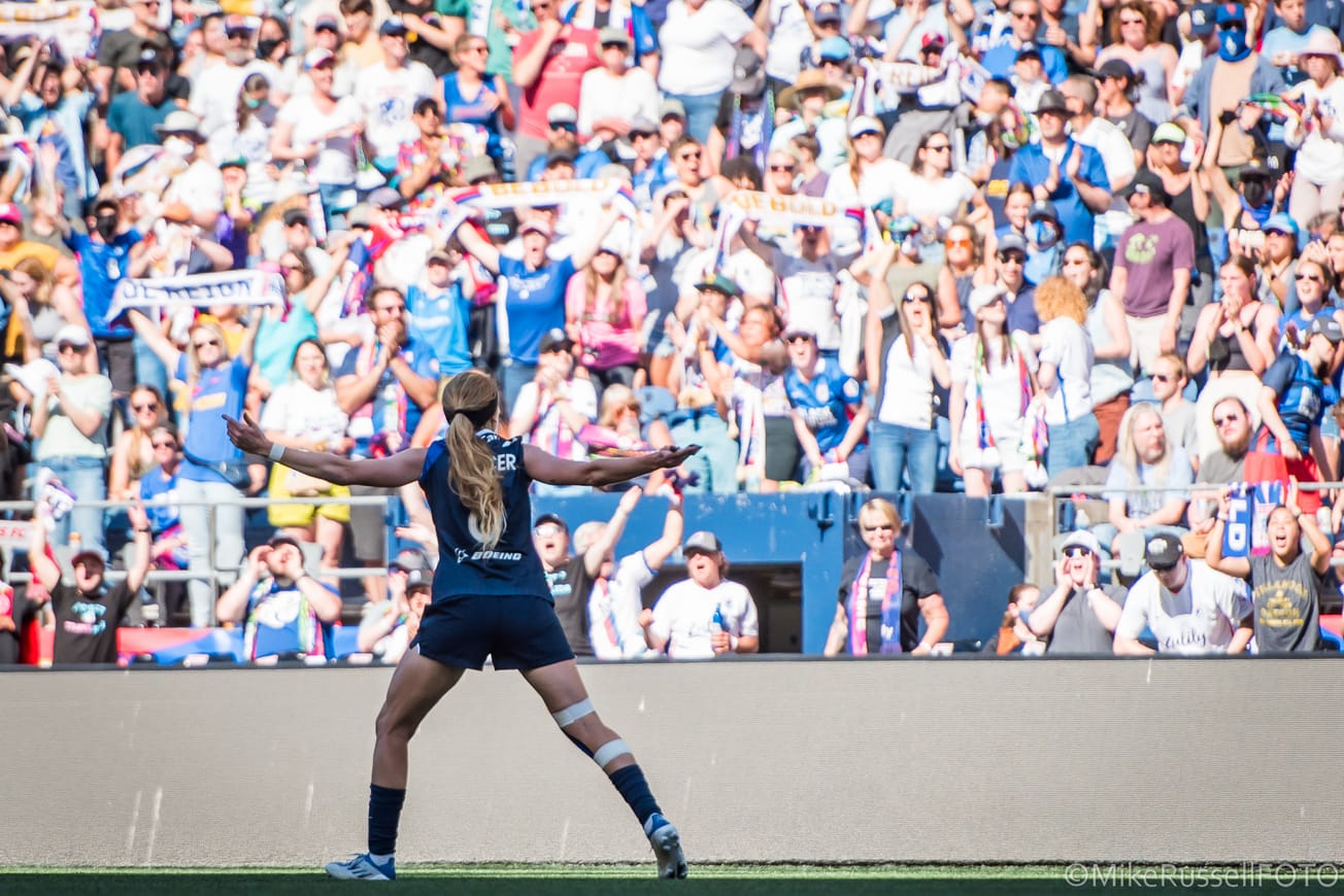 Reign forward Bethany Balcer gestures to the crowd after scoring a goal in a 2022 Reign match vs. Portland.