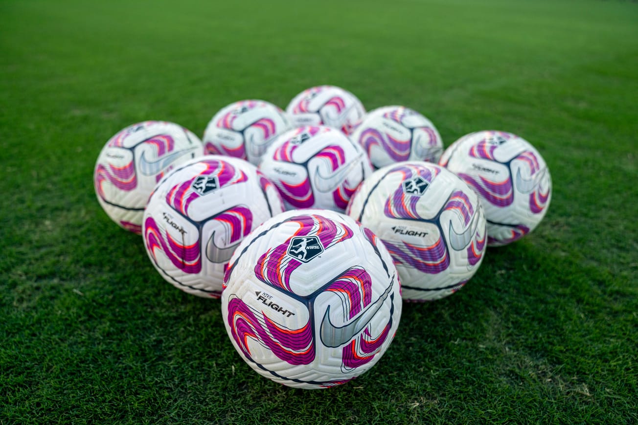 A collection of NWSL soccer balls in a diamond shape.