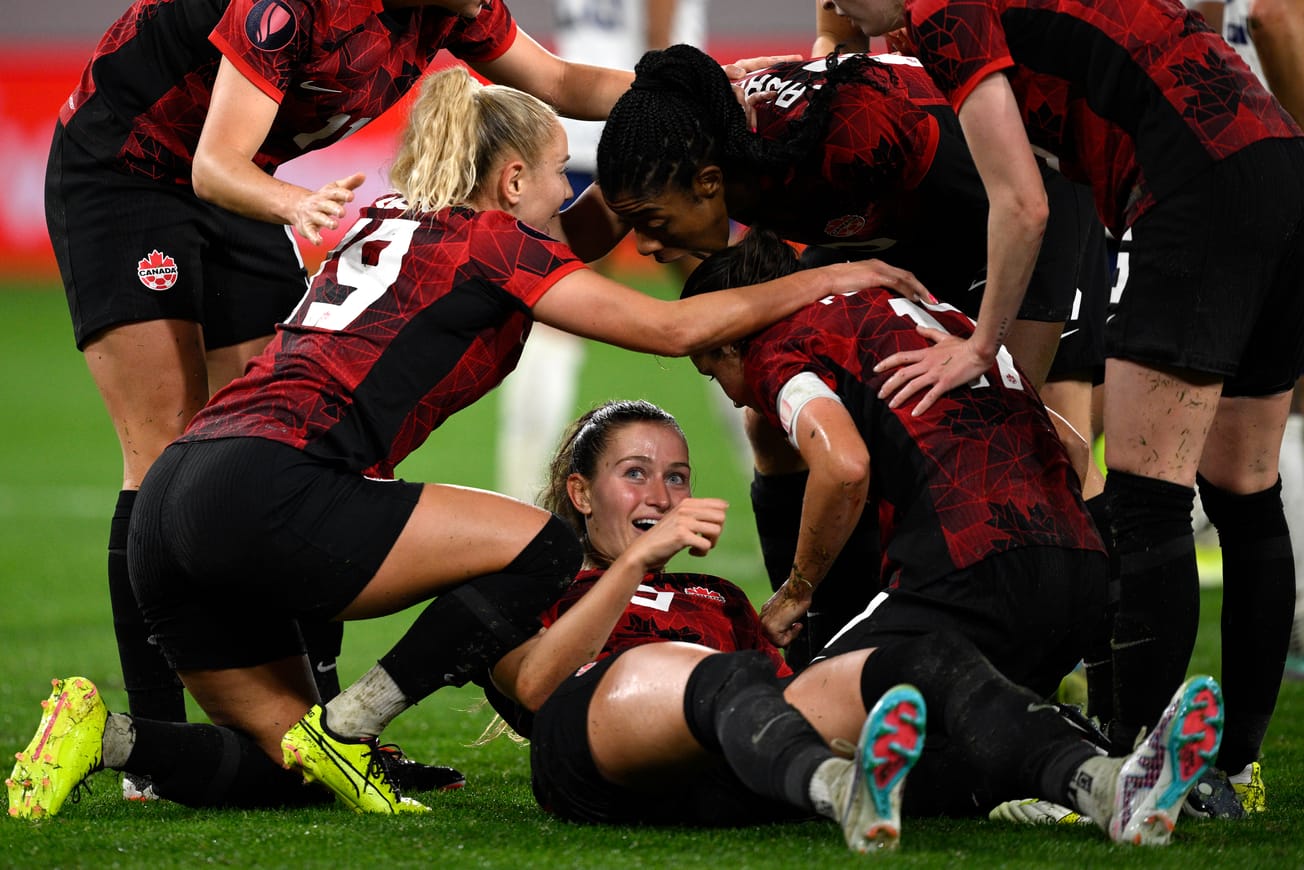 Canada and seattle Reign forward Jordyn Huitema (on ground) is surrounded by Canada teammates after scoring a goal on March 