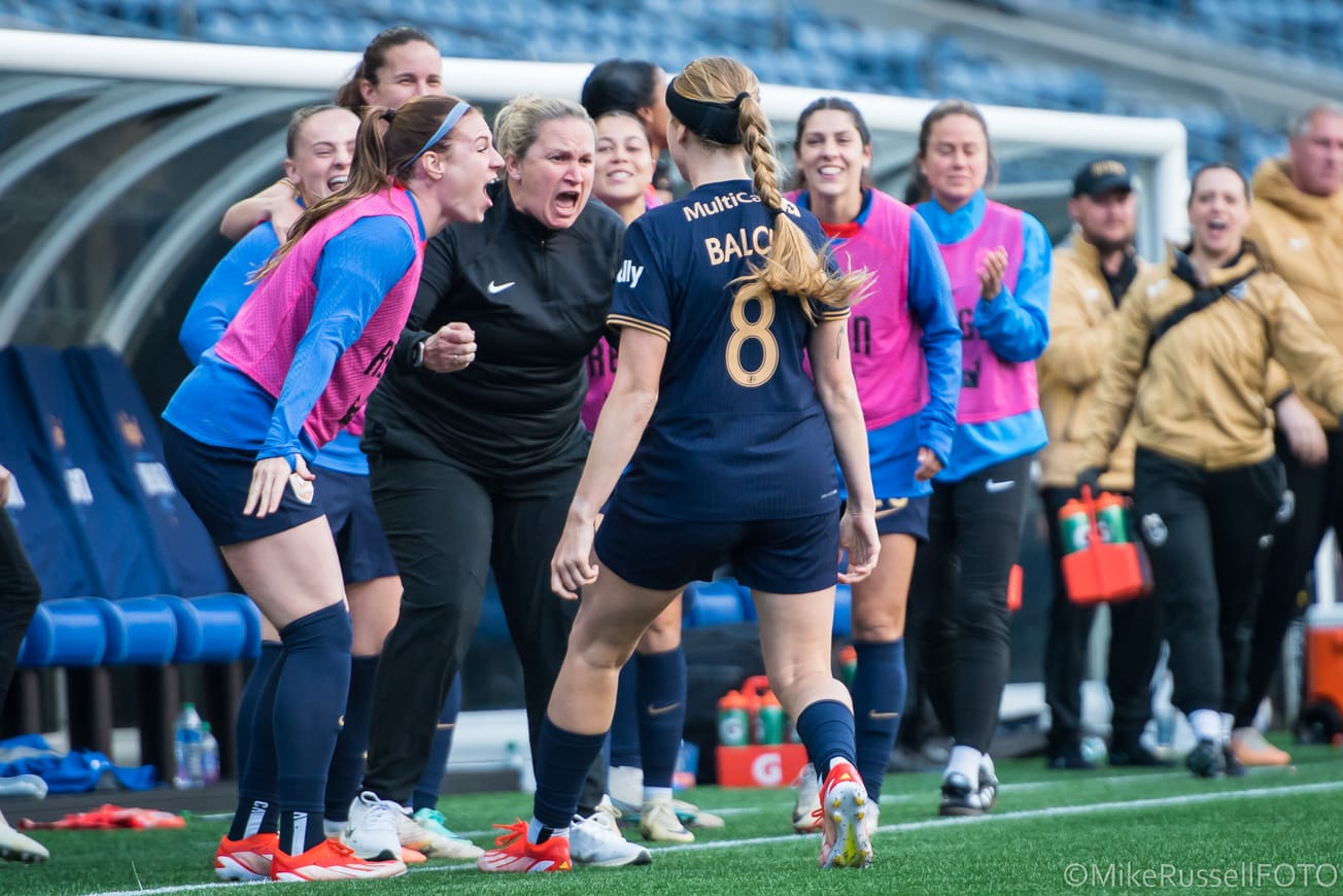 Reign forward Bethany Balcer celebrates with her coach and teammates after a goal against Orlando in May 2024.