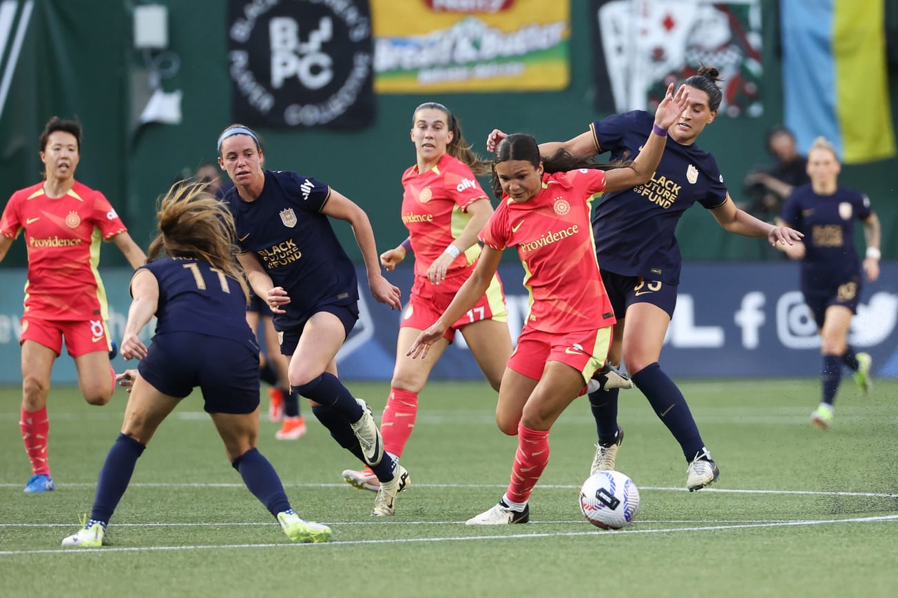 Sophia Smith of the Portland Thorns takes on Sofia Huerta and Olivia van der Jagt of Seattle Reign in a May 2024 match.