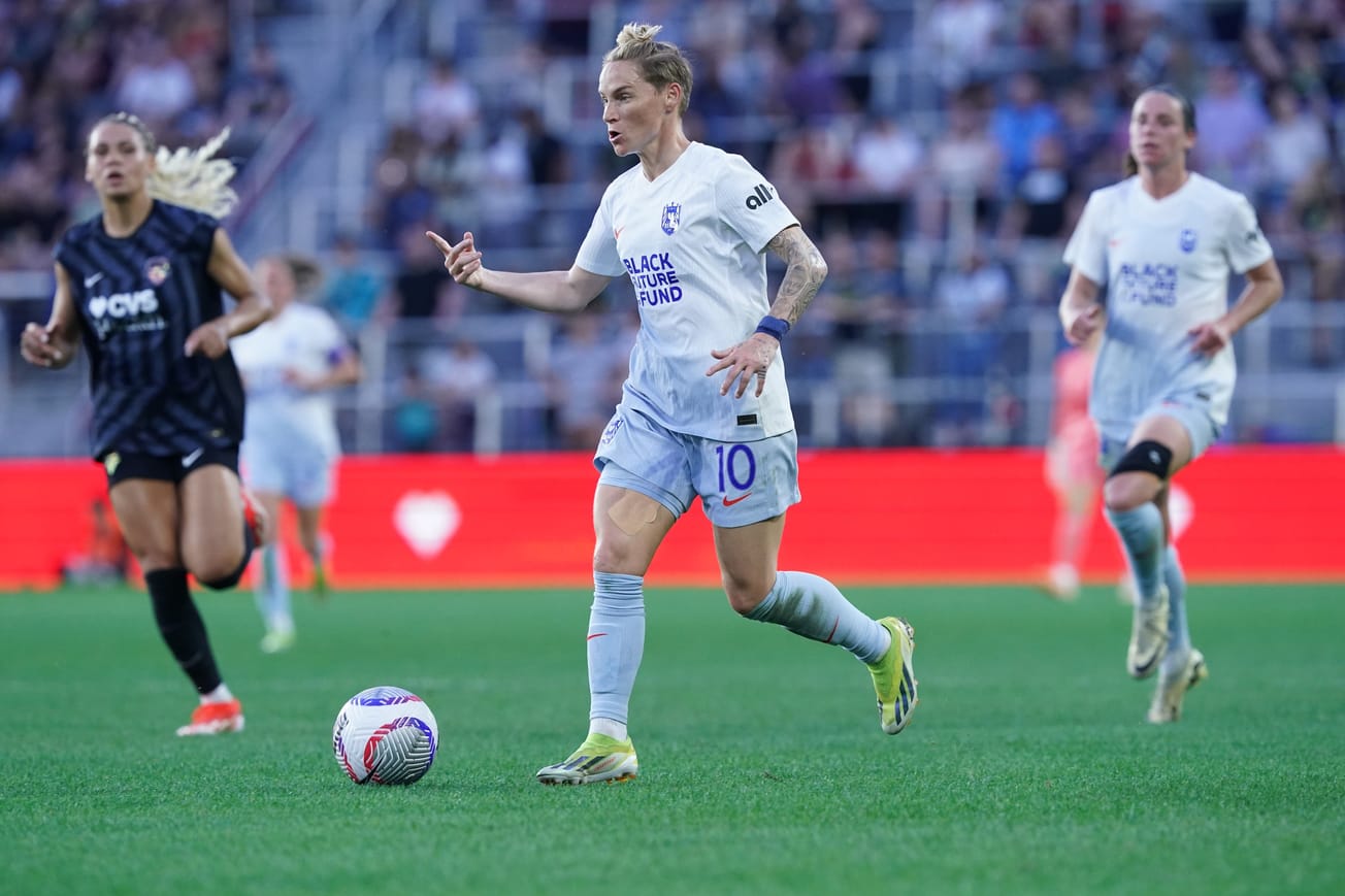 Jess Fishlock of Seattle Reign FC gestures while dribbling against the Washington Spirit in a May 2024 match.