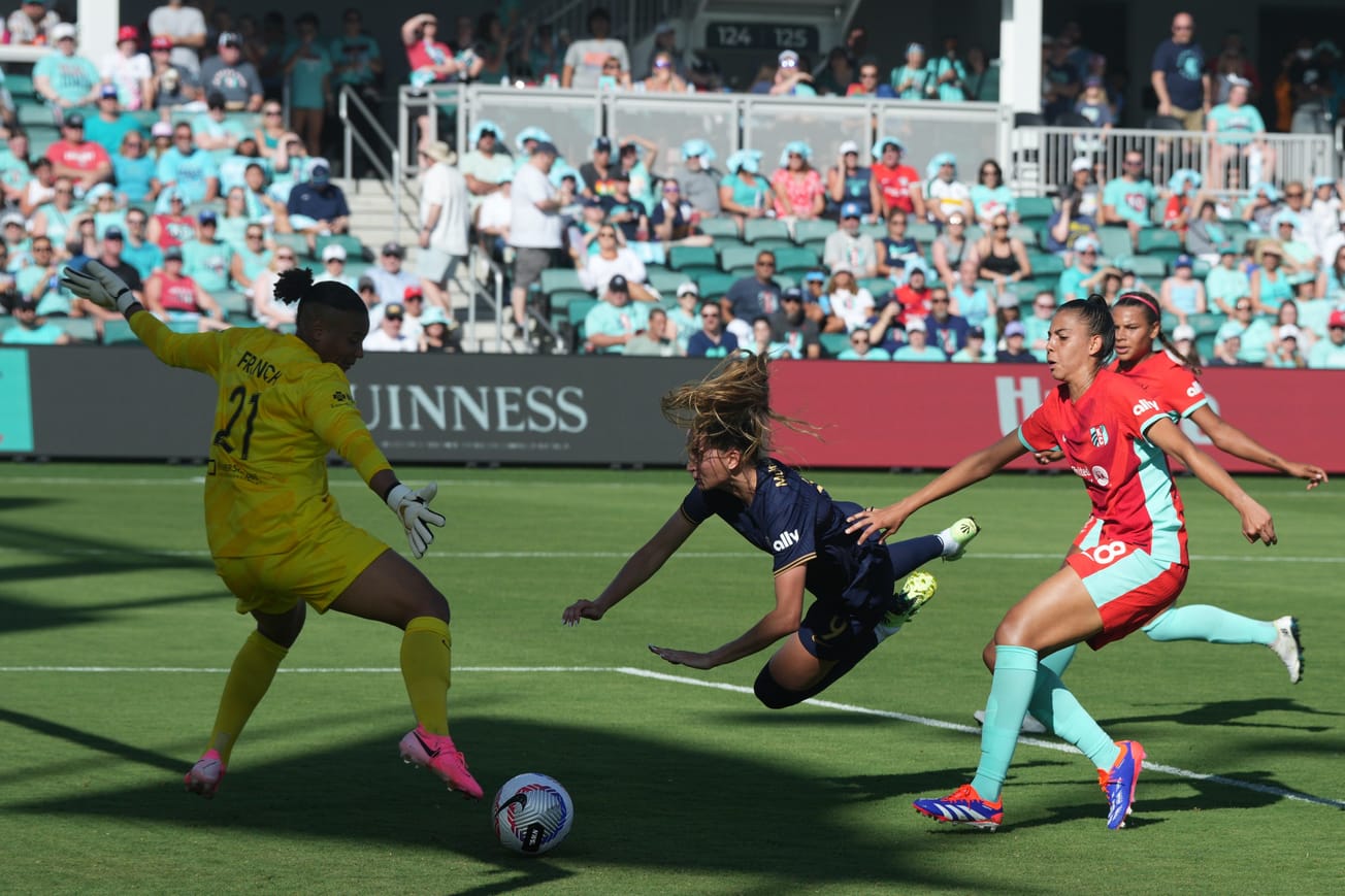 Reign forward Jordyn Huitema dives to score a headed goal against Kansas City in NWSL play.