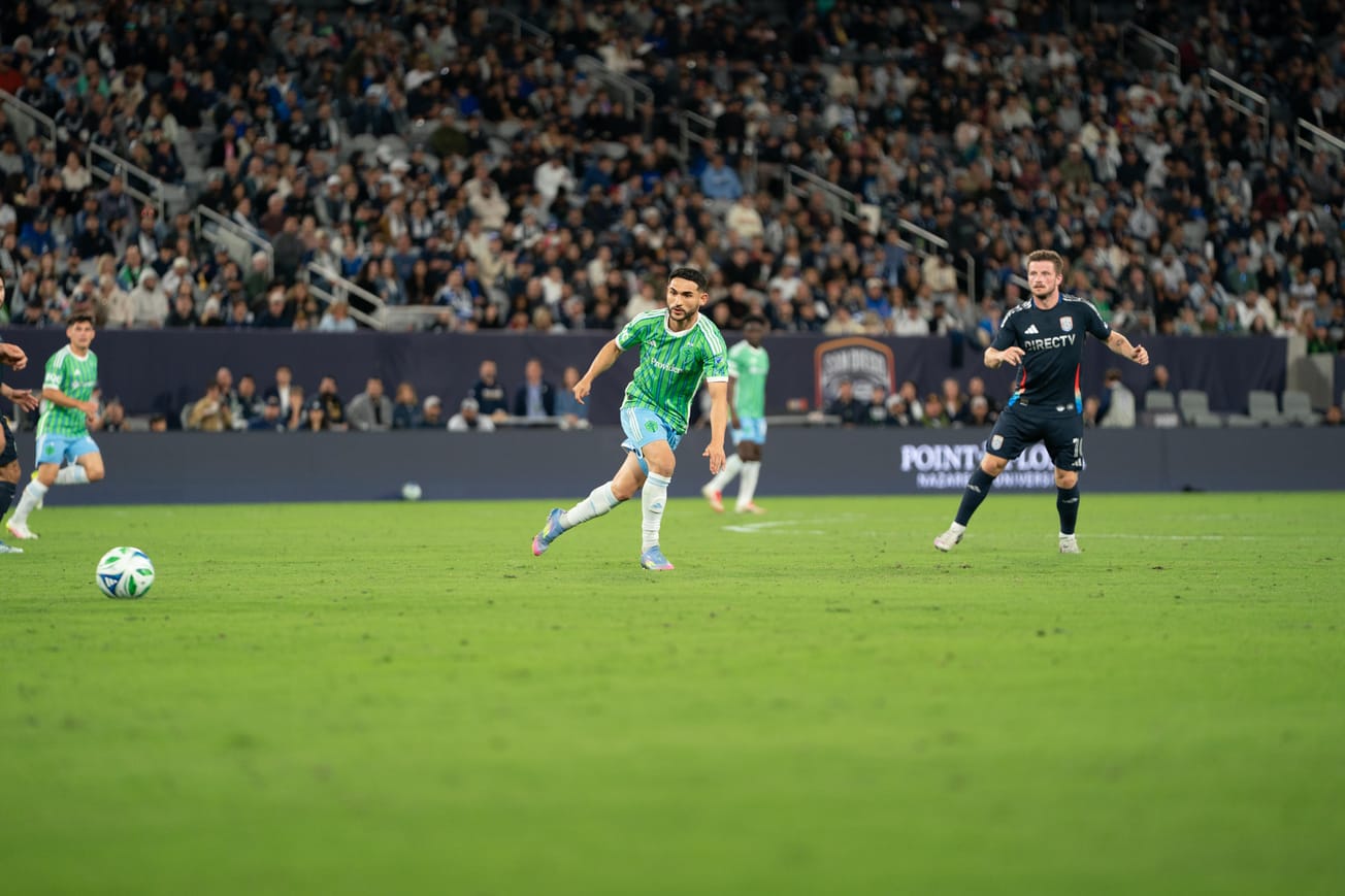 Cristian Roldan runs alongside a San Diego FC player with the ball ahead of him.