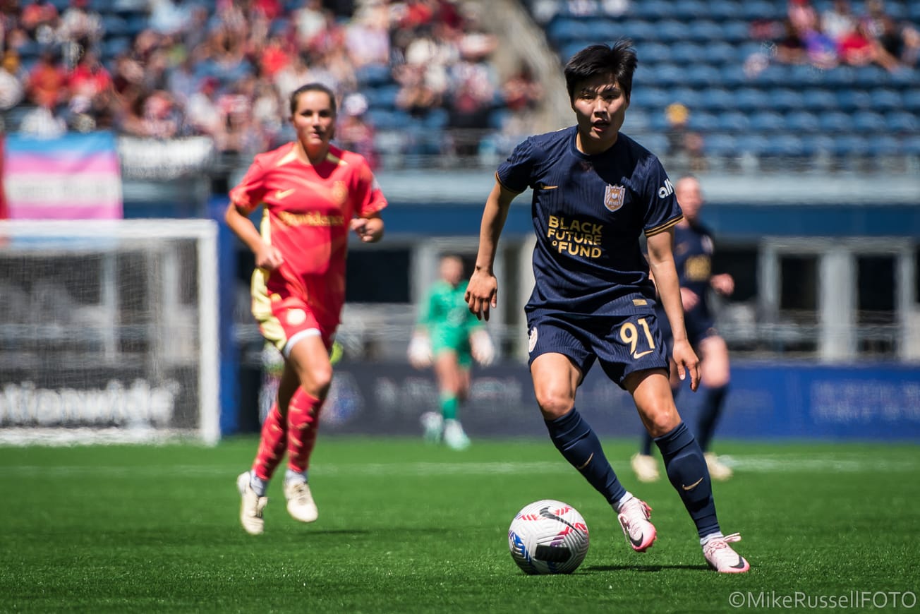 Reign midfielder Ji So-Yun dribbles in a 2024 match against the Portland Thorns.