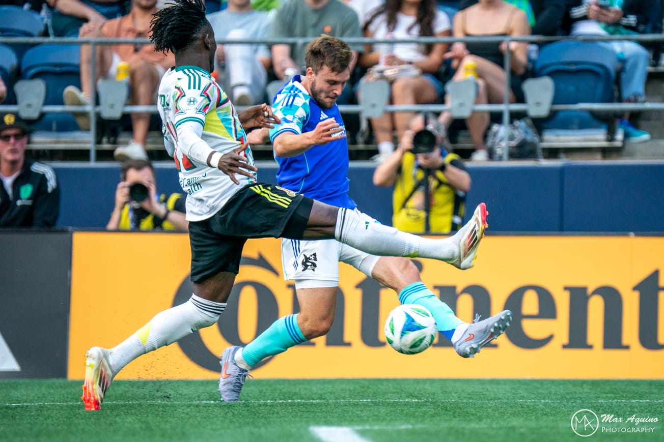 Pedro de la Vega crosses a ball in while being defended by an Earthquakes player