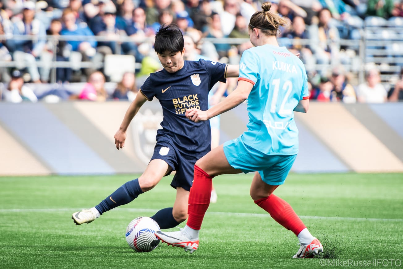 Ji So-yun dribbles against Chicago Red Stars defender Natalia Kuikka in an April 2024 NWSL match at Lumen Field.