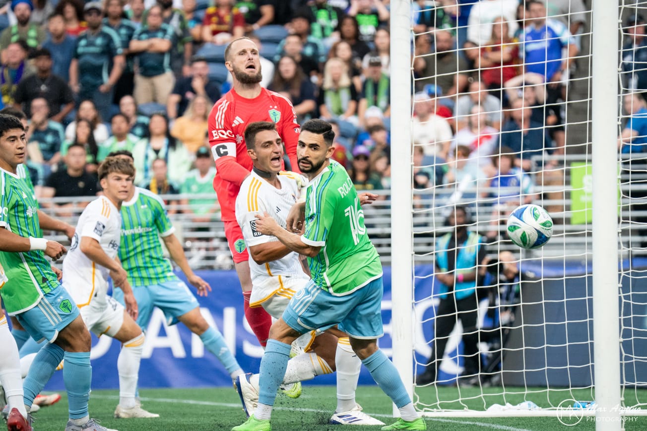 Stefan Frei and other Sounders players look on as the ball flies into their net.