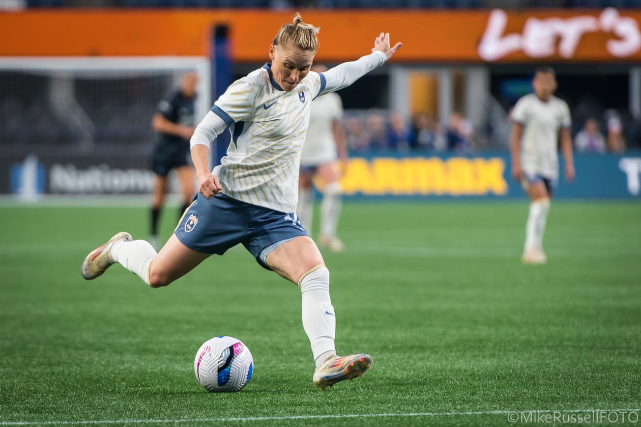 Reign midfielder Jess Fishlock winds up to shoot against the Washington Spirit in a May 2025 match at Lumen Field.